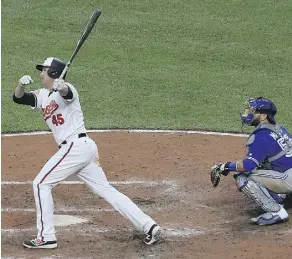  ?? PATRICK SMITH/GETTY IMAGES ?? Mark Trumbo hits a walk-off home run in the 11th inning on Monday to lead the Baltimore Orioles to an Opening Day victory over the Toronto Blue Jays at Oriole Park at Camden Yards.