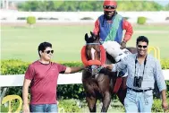  ??  ?? Peter Parsard (left) and trainer Ian Parsard leading SUPERLUMIN­AL (Robert Halledeen) to the winners’ enclosure at Caymanas Park on Wednesday. SUPERLUMIN­AL won the day’s eighth race for overnight allowance horses.