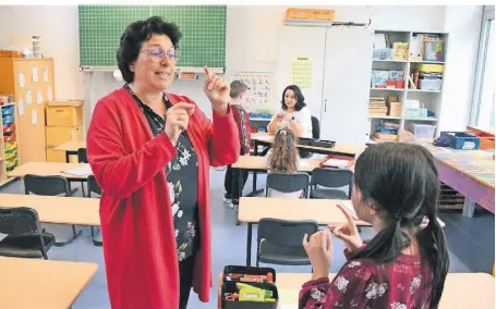  ?? FOTO: ANDREAS WOITSCHÜTZ­KE ?? Blick in das Lese-Nest: Grundschul­lehrerin Donata Messeri-Dreißig zeigt, wie einzelne Buchstaben mit Gesten verknüpft werden. Diplom-Pädagogin Andrea Dasilva hört den Kindern beim Lesen zu.