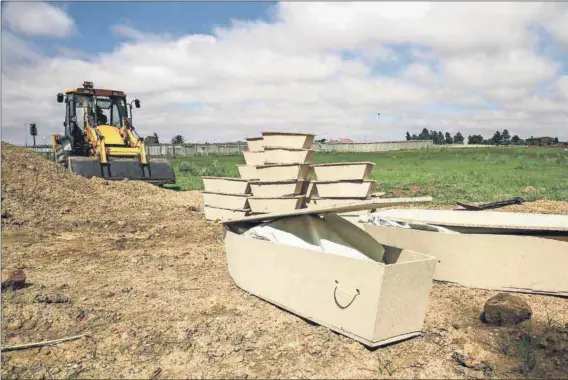  ?? Photos: Kristen van Schie ?? Potter’s field: The undertaker’s employees, whose protective clothing is minimal, bury the coffins of seven adults and 30 babies in three graves in Doornkop cemetery in Dobsonvill­e, Soweto. The city official has ticked their names off on a list.