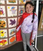  ?? COURTESY ?? A Courageous Kid models her superhero cape in front of a quilt donated by Clareen Dunivin for a drawing at the 33rd Courageous Kids Day, an event that provides “a day away from cancer” each year to hundreds of young cancer patients and their families at California's Great America.