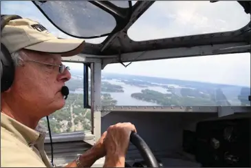  ?? The Sentinel-Record/Grace Brown ?? HIGH VISIBILITY: Pilot Bill Sleeper guides a 1929 Ford Tri-Motor airplane over Lake Hamilton during a special media flight on Thursday. The Experiment­al Aircraft Associatio­n is giving tours and rides in the aircraft through Sunday.