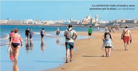  ?? // EP / NACHO FRADE ?? La catedral de Cádiz al fondo y unos paseantes por la playa