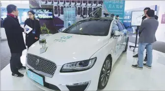  ?? LONG WEI / FOR CHINA DAILY ?? A self-driving car applied the 5G technology catches visitors’ eyes at the China (Hangzhou) 5G Innovation Park in Zhejiang province.