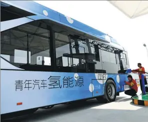  ?? LI CUNGEN / XINHUA ?? A bus that runs on hydrogen fuel cells is charged by technician­s in Rugao city, Jiangsu.