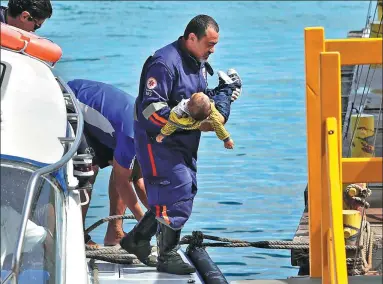  ?? XANDO PEREIRA / FUTURA PRESS VIA AP ?? A rescue worker carries an unconsciou­s child found in the water after a passenger boat carrying more than 100 people sunk in Salvador, Brazil, on Thursday. The boy died en route to a hospital, officials said. A total of 18 people drowned, while 89...