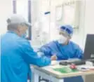  ?? ?? A Yueyang doctor checks the pulse of a patient visiting the clinic. — Ti Gong