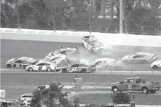  ?? Phelan M. Ebenhack/Associated Press ?? ■ Paul Menard (21) spins in Turn 3, starting a multi-car pileup during the NASCAR Clash auto race Sunday at Daytona Internatio­nal Speedway in Daytona Beach, Fla.on