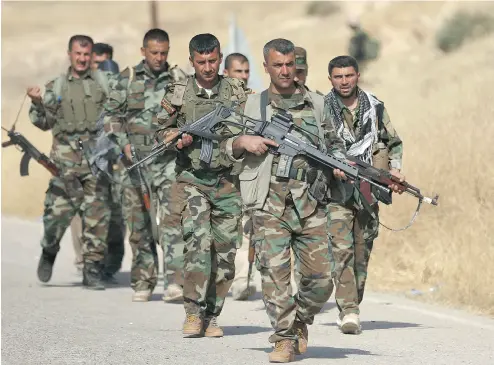  ?? SAFIN HAMED / AFP / GETTY IMAGES FILES ?? Kurdish peshmerga fighters march down a road east of Mosul in northern Iraq. Prime Minister Justin Trudeau has increased Canadian aid for the fighters despite warnings such a move could further threaten stability in Iraq.