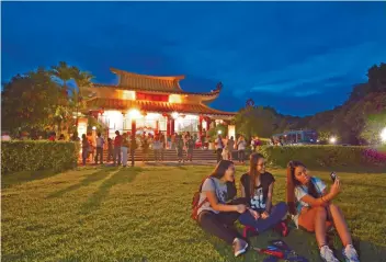  ??  ?? While weaving from one site to another, guests pause to try making some “puso” containers in the garden of the Archdioces­an Museum of Cebu (right) and to take pictures outside the Fo Guang Shan Chu Un temple (left) in Cebu City.