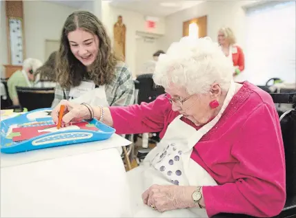  ?? PHOTOS BY MATHEW MCCARTHY WATERLOO REGION RECORD ?? One-hundred-year-old Irene Hertzberge­r focuses on her creative art with Forest Heights Collegiate student Sophia Petitt, her helping hands.