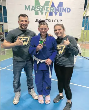  ?? —photo fournie ?? Le deuxième tournoi de jiu-jitsu brésilien de 2020, tenu à Hawkesbury, a attiré de nombreux jeunes. Steve Loiselle et Ashley Létourneau, propriétai­res de l’école d’arts martiaux Flowater de Hawkesbury, entourent leur élève Chloé Séguin, 12 ans, qui a obtenu une médaille d’argent.