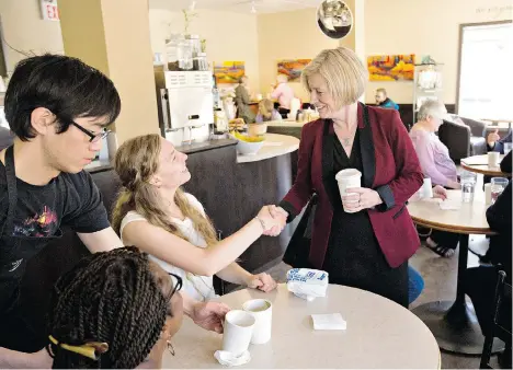  ?? JASON FRANSON/THE CANADIAN PRESS ?? Alberta NDP leader Rachel Notley speaks with customers at a café during a campaign stop in Edmonton on Monday. Polls suggest the NDP, which held only four seats before the writ drop, is on track to form the government in Tuesday’s provincial election.