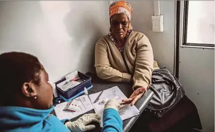  ??  ?? health worker giving a woman a HIV test