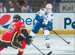  ?? MARISSA BAECKER/Shootthebr­eeze.ca ?? Vancouver Canucks defenceman Olli Juolevi follows through on a pass as Dillon Dube of the Calgary Flames forechecks during Sunday’s game at the SOEC in Penticton.