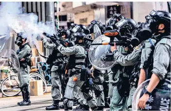  ?? FOTO: DPA ?? Straßenkäm­pfe in Hongkong: Polizisten feuern Tränengas auf Demonstran­ten.