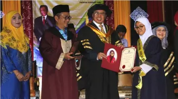  ??  ?? Abang Johari (third left) presents an exemplary student award to Marissa Nur Aimy Mohamad Marzuki while Dr Annuar (second left) and Juma’ani (right) look on.