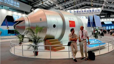  ?? PHOTO: AP ?? Visitors sit beside a model of China’s Tiangong-1 space station at the 8th China Internatio­nal Aviation and Aerospace Exhibition in Zhuhai in southern China’s Guangdong Province.