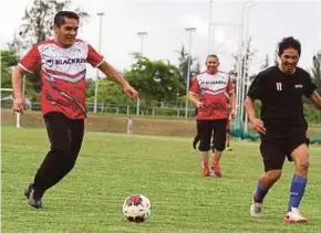  ?? PIX BY MALAI ROSMAH TUAH ?? Dr Radzi Jidin (left) joined the local community in a friendly football match at the Kudat Sports Complex.