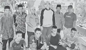  ??  ?? KENANGAN:Dr Hazland bersama tetamu jemputan lain merakam kenangan bersama pasukan yang dinobatkan sebagai pemenang Pertanding­an Futsal Pemuda PBB 2018.