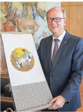  ?? FOTOS HANS-JÜRGEN BAUER ?? Landtagspr­äsident André Kuper zeigt ein edles Seidengemä­lde aus Fernost.