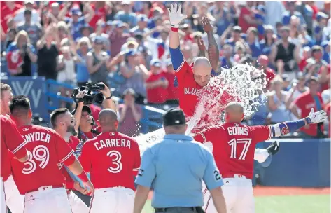  ?? TOM SZCZERBOWS­KI/GETTY IMAGES ?? Toronto Blue Jays players celebrate with teammate Steve Pearce as he reaches home plate after hitting his second walk-off grand slam in five days. Sunday’s blast capped a seven-run bottom of the ninth as Toronto rallied to beat the Los Angeles Angels...