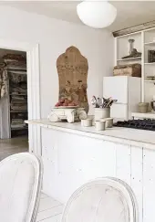  ??  ?? SO FRANZÖSISC­H Links: Die offene Küche mit Blick ins Foyer. Rechts: Das Gemälde auf Stoff zierte einst die Tür in einem Chateau.