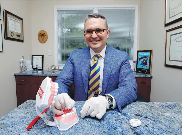  ?? — THE ASSOCIATED PRESS FILES ?? Dr. Wayne Aldredge, president of the American Academy of Periodonto­logy, poses in his office in Holmdel, N.J. A review of 25 studies has determined that flossing, considered to be a health commandmen­t, has no discernibl­e effect on dental health.