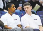  ?? Fred Beckham / Associated Press ?? UConn coach Kevin Ollie, left, and associate head coach Glenn Miller a 2013 men’s basketball game in Hartford. Ollie has filed a lawsuit against Miller, contending Miller slandered him in comments to the NCAA.