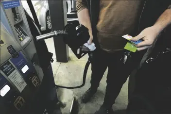  ?? ROGELIO V. SOLIS/AP ?? A customer prepares to pump gasoline into his car at a Sam’s Club fuel island in Gulfport, Miss., on Feb. 19.