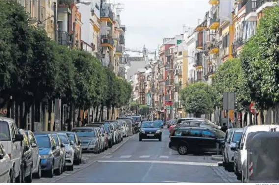  ?? JOSÉ ÁNGEL GARCÍA ?? Un coche circula por la calle Feria entre dos filas de aparcamien­tos repletas de vehículos.