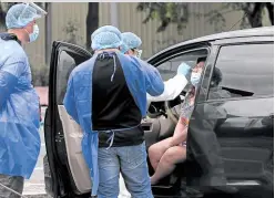  ?? —MARIANNE BERMUDEZ ?? LOCKDOWN EXTENDED A woman undergoes swab testing at a COVID-19 testing facility on Roxas Boulevard in Pasay City, as cases surge in Metro Manila, which will be on modified enhanced community quarantine from April 12 until the end of the month.