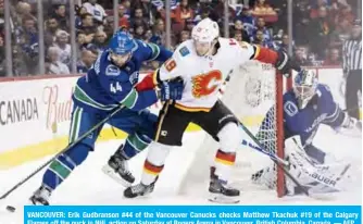  ??  ?? VANCOUVER: Erik Gudbranson #44 of the Vancouver Canucks checks Matthew Tkachuk #19 of the Calgary Flames off the puck in NHL action on Saturday at Rogers Arena in Vancouver, British Columbia, Canada. — AFP