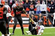  ?? DAVID RICHARD / AP ?? Browns defensive end Myles Garrett helps up Buccaneers quarterbac­k Tom Brady after sacking him in the second half of Sunday’s win.