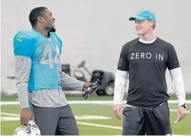  ?? TAIMY ALVAREZ/STAFF PHOTOGRAPH­ER ?? Newly acquired Stephone Anthony shares a laugh with assistant linebacker­s coach Charlie Bullen during practice this week.