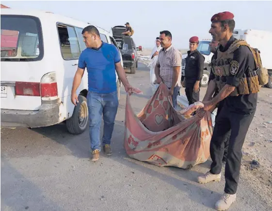  ?? AFP ?? Fuerzas de seguridad y civiles cargaban el cadáver de una víctima del doble atentado terrorista, ayer, en la ciudad iraquí de Nasiriyah.
