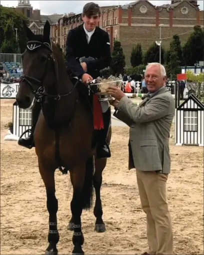  ??  ?? Sligo’s Cian Harrison is presented with the trophy for leading U25 Young Rider by Eddie Macken at last year’s RDS Dublin Horse Show. Cian gets his 2018 season underway this Friday at the four day Mill Street Internatio­nal Show in Cork.