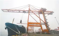  ??  ?? 钦州港码头，正在进行装卸作业 每经记者 张建 摄