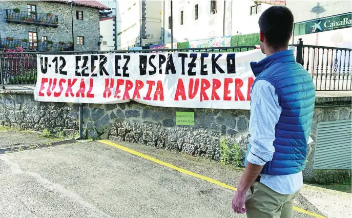  ?? FOTOS: MUÑIZ ?? Un joven del norte de Navarra en el municipio de Leiza observa una pancarta