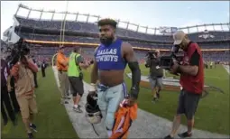  ?? FORT WORTH STAR-TELEGRAM FILE PHOTO ?? Ezekiel Elliott walks off the field after exchanging jerseys with Denver cornerback Aqib Talib after the Broncos beat the Dallas Cowboys, 42-17, on Sunday.