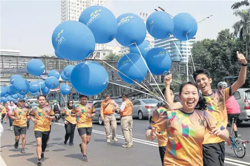  ??  ?? YOUTHFUL ENERGY: Indonesian people arrive to welcome the torch runners during the last torch relay in Jakarta ahead of the opening ceremony of the 2018 Asian Games.