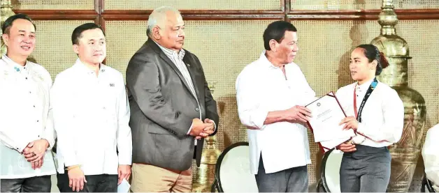  ?? REY BANIQUET/ PRESIDENTI­AL PHOTO ?? AWARDING. President Rodrigo Roa Duterte awards the Presidenti­al citation and incentive to 18th Asian Games weightlift­ing gold medalist Hidilyn Diaz during a ceremony at the Rizal Hall in Malacañan Palace on September 12, 2018.