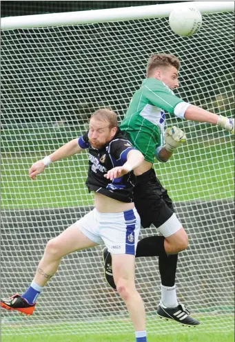  ??  ?? Dundalk Gaels goalkepper, John Burlingham punches the ball away from JP Rooney, Naomh Mairtin during the Group C SFC match in The Grove, Castlebell­ingham on Saturday night. Aidan Dullaghan