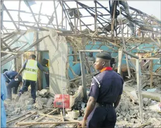  ?? AMINU ABUBAKAR/ AFP/ GETTY IMAGES ?? Security personnel inspect a burned police station that was destroyed by multiple explosions and armed assailants in the Marhaba area of the northern Nigerian city of Kano.