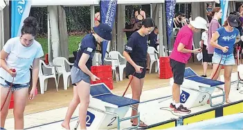  ?? ?? Sophie Millis (centre left) and Emma Pankhurst (centre right) help with time keeping during the Warragul Swimming Club’s training.