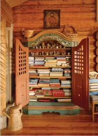  ??  ?? BOTTOM One of the living room’s arch-topped, painted cupboards holds a collection of books and toys from and about Norway.