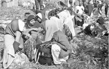  ??  ?? Rohingya refugees, who landed on an isolated northern shore near the Malaysia-Thai border, huddle in a group in Kangar, following their detention by Malaysian immigratio­n authoritie­s. — AFP photo