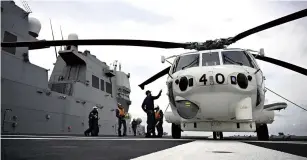  ?? The Yomiuri Shimbun ?? A Maritime Self-Defense Force patrol helicopter is seen aboard a Hyuga-class destroyer in Pacific Ocean waters south of the Kanto region.