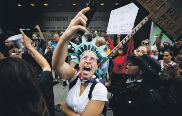  ?? Reuters ?? A New York City schoolteac­her protests against mandatory vaccinatio­n outside the Department of Education headquarte­rs in Brooklyn