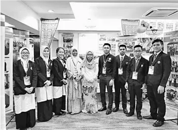  ??  ?? Haslinda (centre) with her teachers and students infront of their exhibition booth.